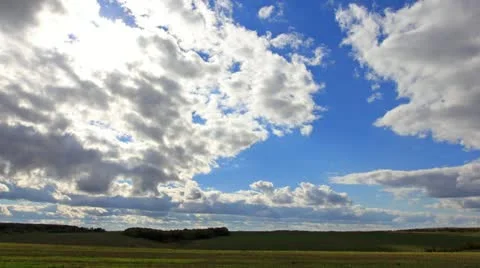 Sun rays, clouds flying on blue sky over field Stock Footage 12248621