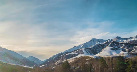 Sun rays emerge through the clouds in the mountains at sunset. Stock Footage 230950096