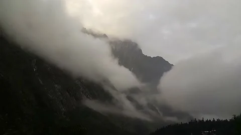 Sun rays emerging though the dark storm clouds in the mountains Stock Footage 171553734