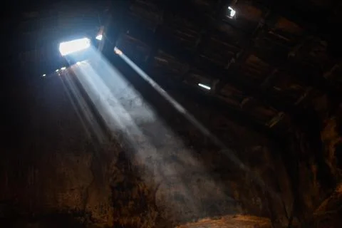 Sun rays enter through the broken roof in house Stock Photos