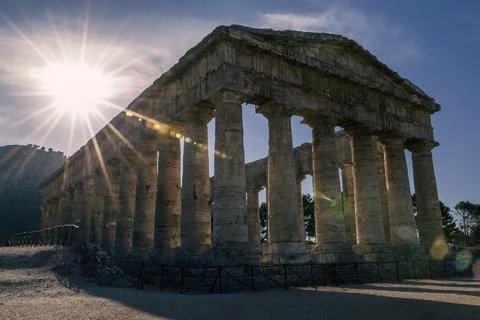Sun rays filter through the columns of the Greek temple of Segesta Foto stock