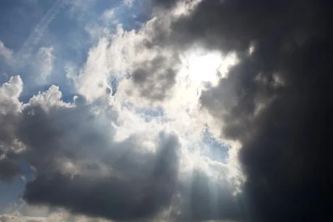 Sun rays filtering through different cloud shapes Stock Photos