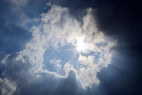 Sun rays filtering through different cloud shapes Stock Photos