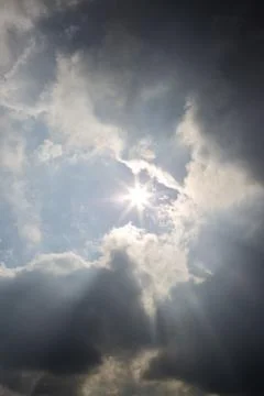 Sun rays filtering through different cloud shapes Stock Photos