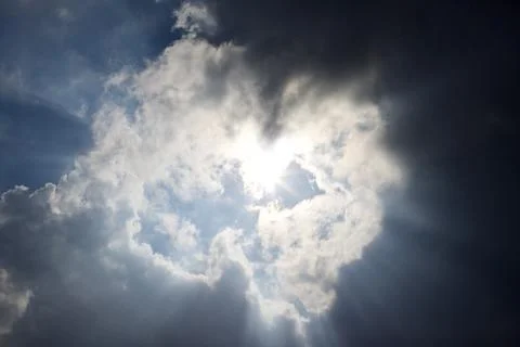 Sun rays filtering through different cloud shapes Foto stock