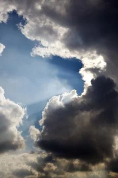 Sun rays filtering through different cloud shapes Foto stock