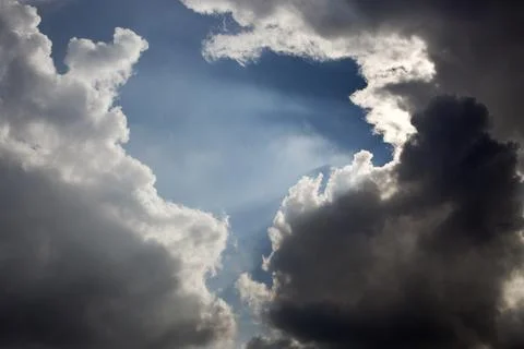 Sun rays filtering through different cloud shapes Stock Photos