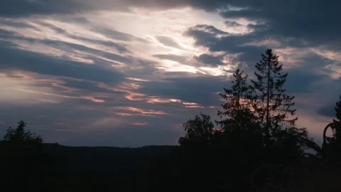 Sun Rays Filtering Through Heavy Evening Clouds Over Forest Ridge Stock Footage 346592993