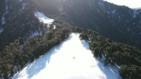 Sun rays in the frame. against sun shot.aerial drone shot of snow mountain Video stock 158070981