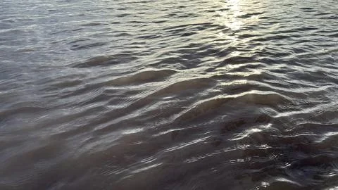 Sun rays gently illuminate the flowing water creating captivating rippled pat Stock Photos