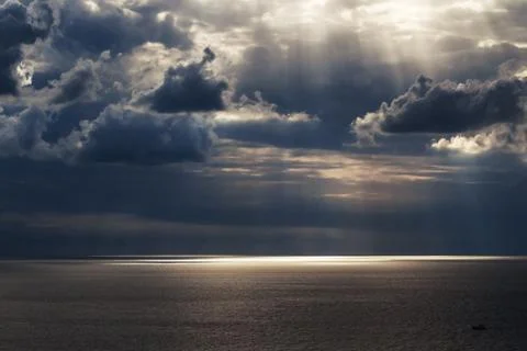 Sun rays getting through the sky on the seascape Stock Photos