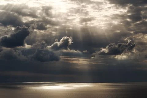 Sun rays getting through the sky on the water Stock Photos
