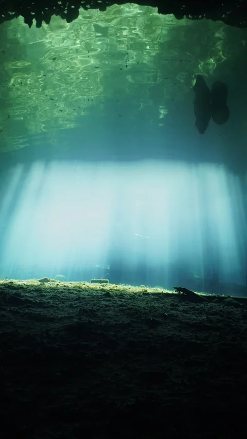 Sun rays illuminating a dark underwater cave creating a magical and ethereal Vídeos de archivo 331524325