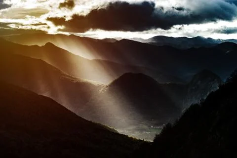 Sun rays lighting through the clouds in high Pyrenees Stock Photos