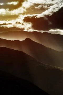 Sun rays lighting through the clouds in high Pyrenees Stock Photos