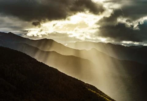 Sun rays lighting through the clouds in high Pyrenees Stock Photos