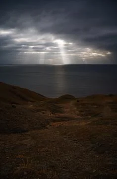 Sun rays make their way through dramatic clouds. Weather turns bad in the Stock Photos
