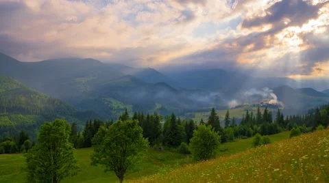 Sun Rays Pass through the Clouds Over the Mountains at Sunset. Stock Footage 68859684