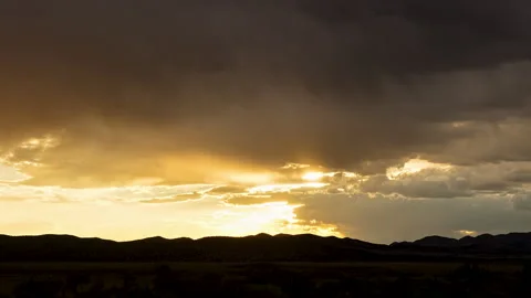 Sun rays peaking out from the clouds during sunset timelapse Stock Footage 344604764