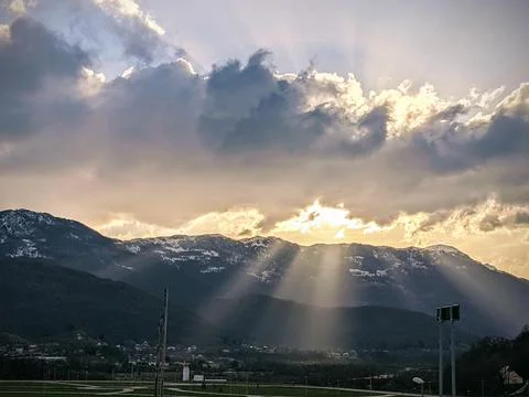Sun Rays piercing through clouds Stock Photos