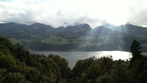 Sun rays push through the cloud cover over the lake Walen in Switzerland. Stock Footage 163327985