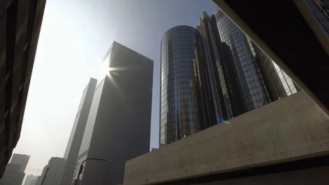 Sun rays reflect in modern skyscrapers in downtown Los Angeles street dolly shot Stock Footage 99116568
