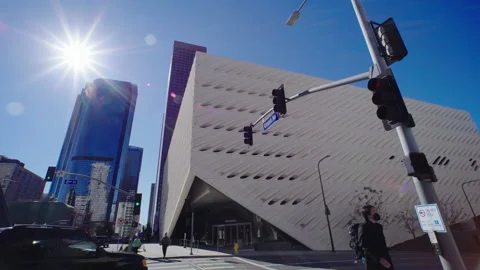 Sun rays shine next to modern skyscrapers. Moving cars and people on city street Stock Footage 169402104