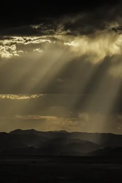 Sun Rays shine through clouds near Jiggs, NV in summer. Stock Photos