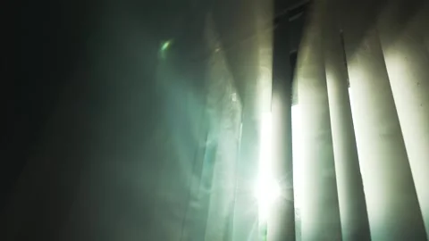 Sun rays shine through the vertical blinds on the window into the dark smoke Vídeo Stock 294668194