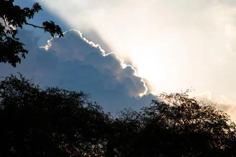 Sun rays shining from behind a big cloud Stock Photos