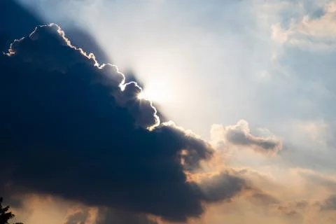 Sun rays shining from behind a big cloud Stock Photos