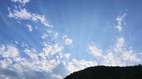 Sun Rays Shining Up From Behind Mountain Into Blue Sky With Clouds Stock-Footage 345185281