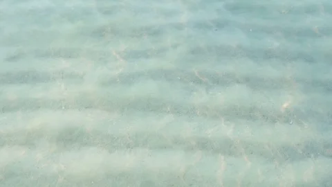 Sun Rays Shining on Pattern of Sand on Ocean Floor Seen Through Shallow Sea Stock Footage 120331775