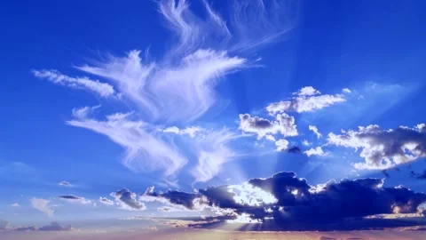 Sun rays shining through clouds in bright blue sky, dramatic sunset light Video stock 328403814
