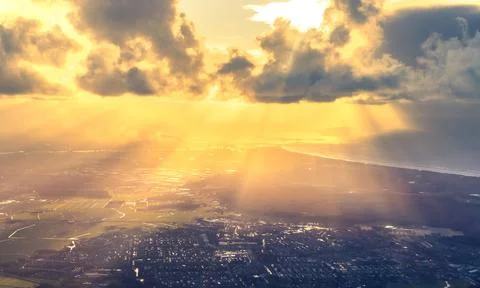 Sun rays shining through clouds above Amsterdam Stock Photos