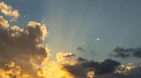 Sun Rays Shining Through Clouds at Sunset 스톡 사진