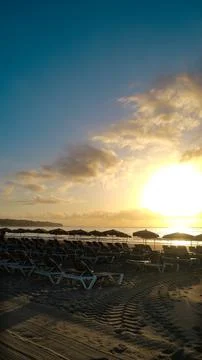 Sun rays shining trough beachbeds on the beach Stock-Fotos