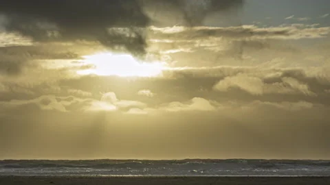 Sun rays sparkle off the ocean waves during sunset at the beach - timelapse Stock Footage 220746210