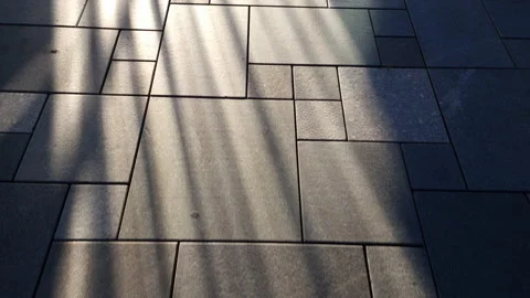 Sun rays on square tiles floor: light falling on the pavement illuminating it Stock Footage 231893953