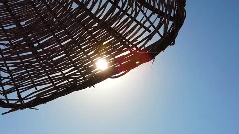 Sun, rays of sun, sunlight shine through wicker beach umbrella from sun. Stock Footage 135272320