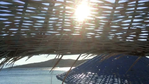 Sun, Rays Of Sun, Sunlight Shine Through Wicker Beach Umbrella in summer time. Stock Footage 145257259