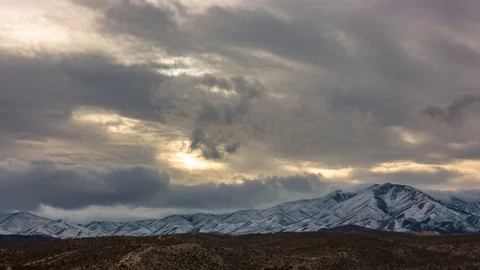 Sun Rays at Sunset with Rolling Snow Clouds Behind Mt. Charleston  Time Lapse Stock Footage 128944786