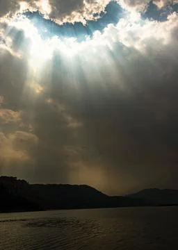 Sun rays through cloud patch at day dramatic scene 写真素材