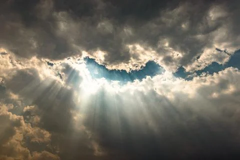 Sun rays through cloud patch at day dramatic scene Фото