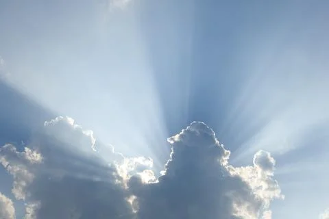 Sun rays through clouds with blue sky Stock Photos