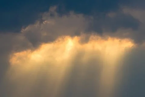 Sun rays through clouds like an dramatic explosion , power nature background. Stock Photos