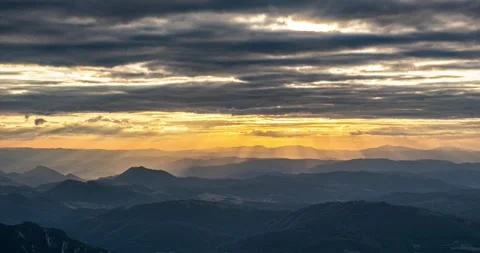 Sun Rays Through Clouds at Golden Sunset in Mountain Landscape Time Lapse Stock Footage 310668834