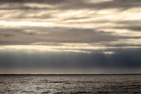Sun Rays Through Clouds near the Ocean Stock Photos