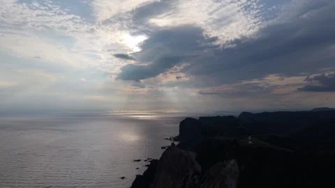 Sun Rays Through Clouds at Shimamui Coast Hokkaido, Shimmering Sea – 4K Aerial Stock Footage 321997816