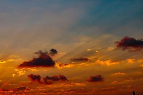 Sun rays through the clouds at sunset. Partly cloudy sky Stock Photos